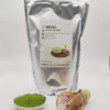 Premium grade Japanese Matcha powder displayed in a dish with a bamboo whisk, in front of J-okini’s 500g Matcha package. Pesticide-free and perfect for traditional tea, Matcha lattes, and sweets. Available at j-okini.com in Malta
