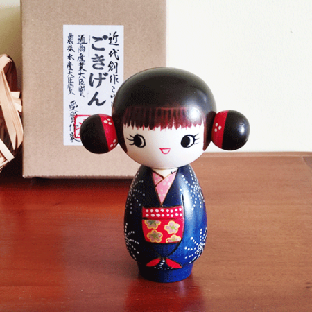 This 近代創作こけし modern creative Kokeshi doll is called 'ごきげん - Gokigen' and it was created by an award-winning artist 'ちえ Chie'. The doll's feature would be the space buns.  Her pretty Kimono has a design of Hanabi (fire works) and the obi (wide sash) has a contrast colour red. Available at j-okini.com Malta
