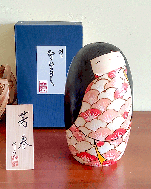 Crafted by the renowned artist 卯三郎 Usaburo, the '芳春 Houshun' Kokeshi doll embodies the essence of spring with its fragrance and beauty. This award-winning piece showcases a kimono adorned with vibrant Ume (Plum blossoms), each petal painted to capture the delicate shades of vermilion, symbolizing the diversity and unity found in nature. The heart of each blossom is highlighted in white, reflecting the warmth of spring, while the doll's elegantly curved hair adds a touch of grace. '芳春 Houshun' is not just a doll; it's a celebration of the season's eternal beauty, inviting you to embrace the charm and elegance of Japanese art and culture. Available at j-okini Malta