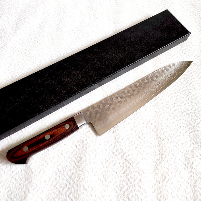 Japanese-Kitchen-Knife-Gyutou-Hammered-VG10-Damascus-1a Japanese Gyutou kitchen knife by Minamoto no Hisahide - an 8-layer VG10 Damascus steel chef’s knife with a beautiful hammered finish. Sharp, durable, and one of a kind.. Available at j-okini.com in Malta