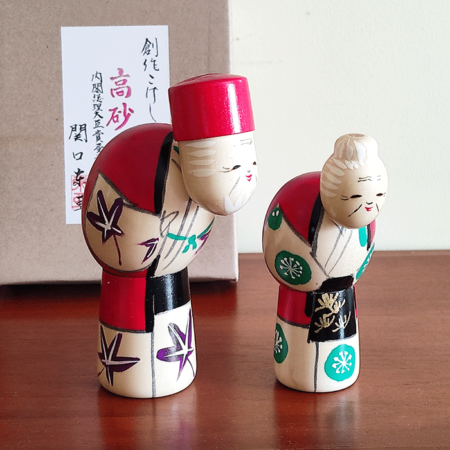 This modern creative Kokeshi doll is called '高砂 Takasago' and it was created by an award-winning artist '関口東亜 Sekiguchi Toua'. Takasago is a traditional Noh play. It is considered a very auspicious story, involving a loving and long-married couple. The play was formerly known as Aioi or Twin Pines This is a cute old couple Kokeshi dolls.  Their posture is cute and their calm smile is also charming. Available j-okini in Malta