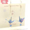 Crafted with meticulous attention to detail, these earrings feature a 3cm piece of Chiyogami, a traditional Japanese washi paper, known for its vibrant and intricate designs. Each pair is carefully sealed with three layers of protective coating to ensure durability and shine. At the heart of these earrings is the motif of the Tsuru, the Japanese word for crane. Revered in Japanese culture, the Tsuru is celebrated as a symbol of peace and longevity, embodying wishes for prosperity and health. These earrings are not only a testament to unique craftsmanship but also carry a deep cultural significance. The design is complemented by a delicate blue glass bead, harmonizing beautifully with the blue Chiyogami paper to create a piece that is both eye-catching and meaningful. Made in Japan. Available at j-okini.com