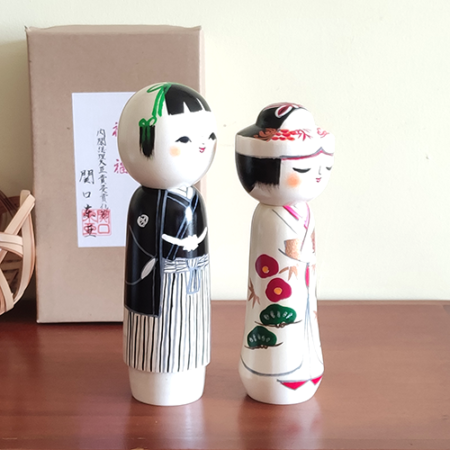 This 近代創作こけし modern creative Kokeshi doll is called '祝福 Shukufuku' and it was created by an award-winning artist  ‘関口東亜 Sekiguchi Toua‘. '祝福 Shukufuku' means 'celebration'.   The couple is wearing Japanese traditional wedding Kimono symbolizing love, unity, and cultural heritage.. Looking for a unique and meaningful gift for a couple who adores Japan? Why not choose '祝福 Shukufuku'? It's not just a gift; it's a gesture that celebrates love, tradition, and the artistry of Japan. Available at j-okini.com in Malta