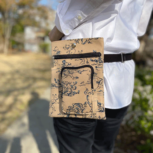 Discover the Essence of Japanese Craftsmanship with Our Handmade Kyoto Bag Crafted with unparalleled attention to detail, this bag embodies the spirit of Kyoto's artisanal heritage. Each piece is meticulously handcrafted by skilled artisans in Kyoto, Japan, using premium materials that blend tradition with durability. It features: - Two secure outer zip pockets for easy access. - An adjustable strap, offering versatile wear as a waist bag or shoulder bag. - A unisex design, making it a perfect accessory for anyone. - Crafted for longevity, ensuring that this bag stands the test of time. A Canvas of Cultural Heritage Adorned with the iconic 鳥獣戯画 Chojyu Giga pattern, this bag pays homage to what is often considered Japan's earliest form of manga. The playful anthropomorphized animals depicted in these scrolls capture the whimsy and depth of Japanese folklore. Color and Composition - Color: Classic Beige, a versatile choice for any wardrobe. - Material: 100% cotton for both the outer and lining - Dimensions: 20cm Width x 25cm Height - Designed to offer ample space for your essentials, this bag combines functionality with aesthetic appeal. Durable Textiles for Everyday Use - Outer material: Hampu 帆布, known for its robust 平織 Hira-ori (plain weave). This technique involves an intricate process of crossing warp and weft threads, enhanced by twisting and weaving multiple threads for unmatched strength. - Lining material: Katsuragi カツラギ, a softer, thinner fabric compared to Hampu, crafted from 綾織 Aya-ori (twill weave). This method creates a diagonal alignment of warp and weft intersections, offering durability with a gentle touch. Available at j-okini.com in Malta