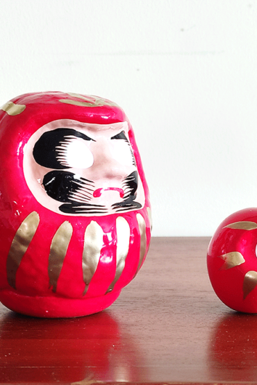 Discover the essence of perseverance and good fortune with our authentic Japanese Daruma doll, meticulously handcrafted in Japan. Traditionally colored in vibrant red, this Daruma doll embodies the spirit of Bodhidharma, the revered founder of Zen Buddhism, in its design and purpose. A Symbol of Determination and Achievement The Daruma doll is more than just a decorative piece; it serves as a powerful talisman for setting intentions or goals. Its unique feature lies in its eyes - left blank for you to engage in the meaningful ritual of painting them yourself: Set Your Goal: Paint the left eye while focusing on your wish or goal, imbuing the Daruma with your personal aspirations. Celebrate Your Success: Once your wish comes to fruition, complete the Daruma's gaze by painting the right eye, a symbolic act of gratitude and acknowledgment of your perseverance. A Thoughtful Gift of Inspiration This Daruma doll, with its rich cultural heritage and symbolic significance, makes for an inspiring gift. Pair it with other Daruma-themed items from our collection to share a message of hope, resilience, and success.