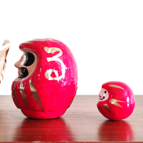 Discover the essence of perseverance and good fortune with our authentic Japanese Daruma doll, meticulously handcrafted in Japan. Traditionally colored in vibrant red, this Daruma doll embodies the spirit of Bodhidharma, the revered founder of Zen Buddhism, in its design and purpose. A Symbol of Determination and Achievement The Daruma doll is more than just a decorative piece; it serves as a powerful talisman for setting intentions or goals. Its unique feature lies in its eyes - left blank for you to engage in the meaningful ritual of painting them yourself: Set Your Goal: Paint the left eye while focusing on your wish or goal, imbuing the Daruma with your personal aspirations. Celebrate Your Success: Once your wish comes to fruition, complete the Daruma's gaze by painting the right eye, a symbolic act of gratitude and acknowledgment of your perseverance. A Thoughtful Gift of Inspiration This Daruma doll, with its rich cultural heritage and symbolic significance, makes for an inspiring gift. Pair it with other Daruma-themed items from our collection to share a message of hope, resilience, and success.