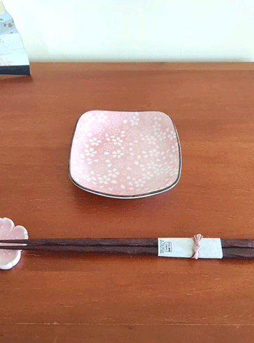 This charming set features a light pink Sakura plate paired with a matching Sakura-shaped chopstick rest. The square plate, adorned with delicate cherry blossom (Sakura) patterns, has a slight depth, making it perfect for serving soy sauce or small side dishes. Both pieces are crafted in the Mino ware (Mino-yaki) tradition, a celebrated Japanese pottery style known for its beautiful and functional designs. Available at j-okini.com in Malta