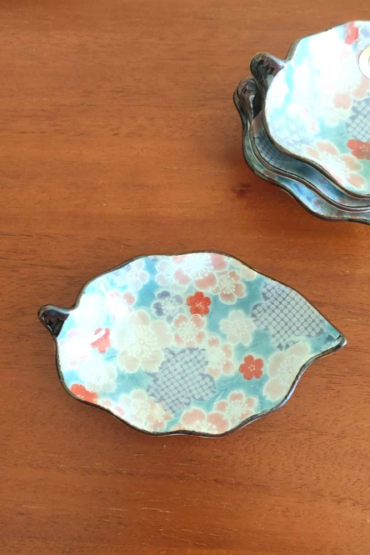 Aritaware Small Porcelain Leaf Plate with Sakura Design With a history dating back to the 4th century, Aritaware represents centuries of Japanese craftsmanship and tradition. Each piece reflects the skill and artistry of master craftsmen, beautifully preserved for the present. This elegant leaf-shaped porcelain plate features a delicate sakura (cherry blossom) design in light blue, making it both charming and versatile. Perfect as a soy sauce dish, for serving condiments, or even as a stylish holder for accessories on your bedroom dresser. Made in Japan, this plate embodies timeless artistry and functionality. Available at j-okini.com in Malta