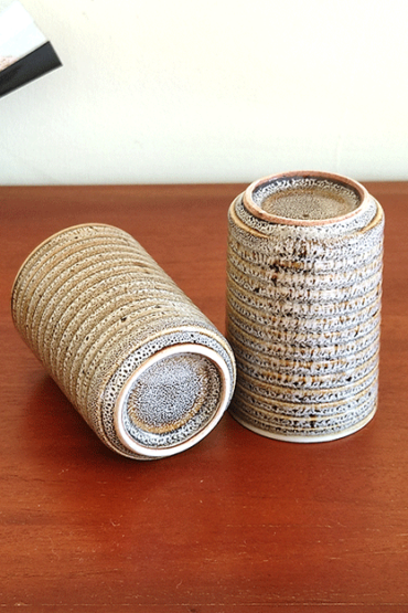 A Japanese vintage teacup in a rich golden-brown hue with an elegant tall, straight shape combined with a textured border design and a beautifully dotted glaze. The intricate details and refined Japanese craftsmanship make it a standout piece. Available at j-okini.com in malta