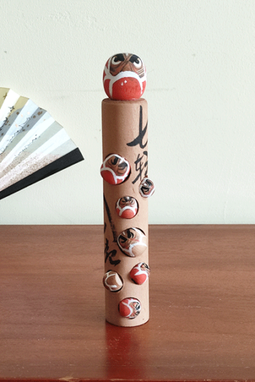 Vintage wooden Daruma doll with seven smaller Daruma figures, inscribed with the proverb 'Nanakorobi Yaoki' for resilience, stamped from Kawayu Onsen area, 17.5 cm tall with craftsman's mark. Available at j-okini.com in Malta