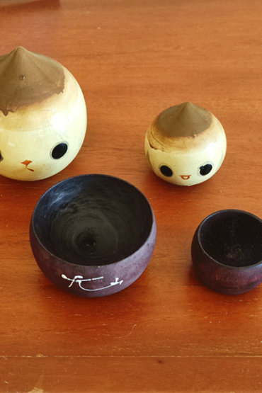A pair of vintage wooden dolls shaped like acorns, with removable tops representing the acorn heads. The dolls show signs of age with slight scratches. One is larger, measuring approximately H10 x W6.5cm, and the smaller one is H6.5 x W4cm. These unique pieces come from a personal collection in Japan, tied to Mount Daisen in Tottori Prefecture.. Available at j-okini.com in Malta