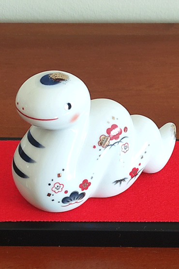 Porcelain Japanese Zodiac white snake figurine with a charming expression, decorated with pine, bamboo, and plum patterns, symbolizing prosperity and renewal. Buy at j-okini in Malta