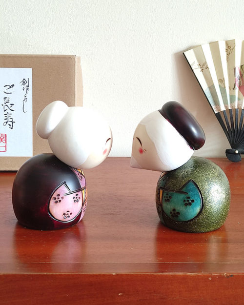 A modern Creative Kokeshi doll set named 'Gochouju' by award-winning artist Sekiguchi Toshio. The dolls depict an elderly couple with kind smiles, dressed in elegant kimono, celebrating longevity and happiness. Handcrafted in Japan. Available at j-okini.com in Malta