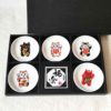 A set of five Japanese Maneki-Neko small dishes, each featuring a unique beckoning cat design symbolizing luck, protection, happiness, prosperity, and wealth. Perfect for serving soy sauce or condiments. Made in Japan. Available at j-okini.com in Malta