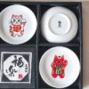 A set of five Japanese Maneki-Neko small dishes, each featuring a unique beckoning cat design symbolizing luck, protection, happiness, prosperity, and wealth. Perfect for serving soy sauce or condiments. Made in Japan.