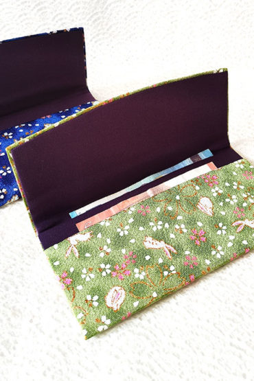 A Hana Chirimen Kimono Wallet with a bunny and sakura pattern, featuring a fold-over design. Made from Kyoto's traditional Chirimen fabric. Available in green or blue. Available at j-okini.com in Malta