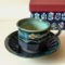 Handcrafted Kiyomizu Ware coffee cup and saucer in deep Oribe green by Ando Mitsuru, showcasing texture contrasts and traditional Japanese craftsmanship. Buy it from j-okini in Malta