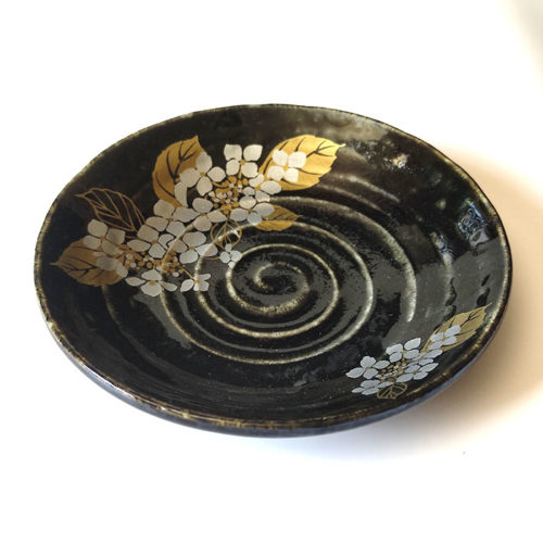 Black porcelain plate with a spiral-carved surface and gold and silver painted Hydrangea – part of a seasonal Japanese Mino-yaki plate set. Available at j-okini.com in Malta