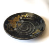 Black porcelain plate with a spiral-carved surface and gold and silver painted plum blossoms – part of a seasonal Japanese Mino-yaki plate set. Available at j-okini.com in Malta