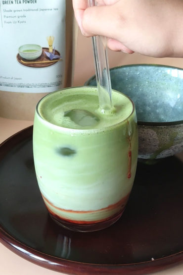 strawberry matcha latte in a glass and ice cube