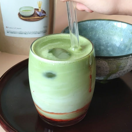 strawberry matcha latte in a glass and ice cube