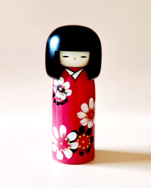 Hana Guruma Kokeshi doll in dark red kimono with white and black flowers, handcrafted in Japan by Usaburo. Buy it online at j-okini.com in Malta