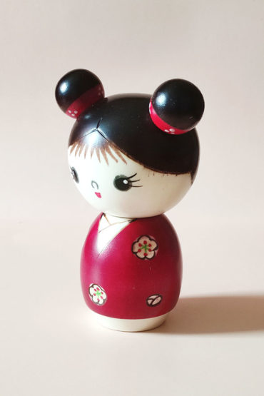 Cute Japanese wooden doll – Mujaki Kokeshi in vibrant red kimono with carved flowers, handcrafted by Chie. Buy it online at j-okini.com in Malta