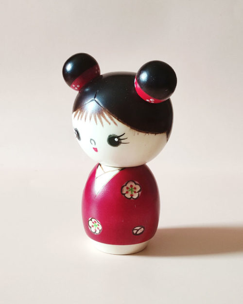 Cute Japanese wooden doll – Mujaki Kokeshi in vibrant red kimono with carved flowers, handcrafted by Chie. Buy it online at j-okini.com in Malta