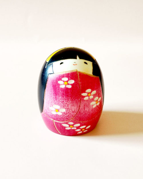 "Negai Kokeshi doll in pink floral kimono with yellow hair ribbon, handcrafted in Japan by Usaburo. Buy online at j-okini.com in Malta