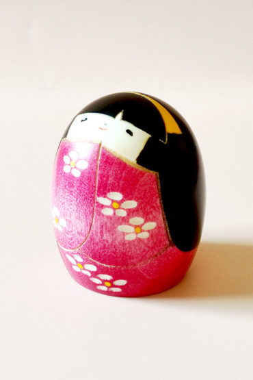 Handmade Negai wooden Kokeshi doll with round smiling face and floral pink kimono by Usaburo.. Buy it online at j-okini.com in Malta