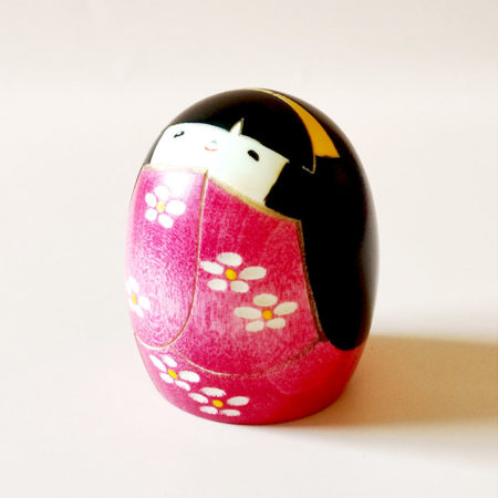 Handmade Negai wooden Kokeshi doll with round smiling face and floral pink kimono by Usaburo.. Buy it online at j-okini.com in Malta