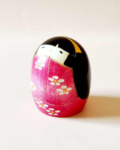 Handmade Negai wooden Kokeshi doll with round smiling face and floral pink kimono by Usaburo.. Buy it online at j-okini.com in Malta