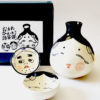 Japanese ceramic sake set with Okame and Hyottoko designs. Made in Japan. Available at j-okini.com in Malta