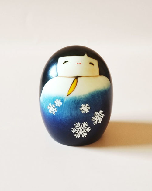 Yuki no Sei Kokeshi doll in deep blue snowflake kimono with white sleeves and yellow inner lining, handcrafted by Usaburo in Japan. buy online at j-okini.com in Malta