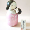Standing at 19.5 cm tall, this large creative Kokeshi features a mother gently cradling her baby inside a shimmering silver and pink haori. The sparkling pink hue adds a soft, dreamlike glow, while delicate sakura (cherry blossom) motifs adorn the robe. j-okini.com in Malta