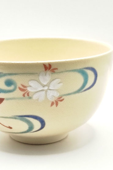 Vintage handmade Kyo-yaki Matcha bowl with maple leaf and sakura design on cream glaze, accented with blue curved lines.