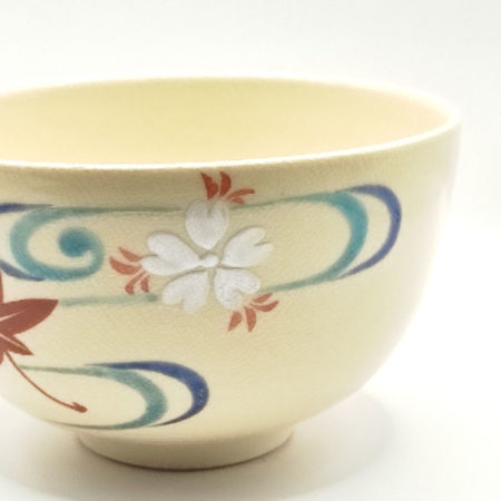 Vintage handmade Kyo-yaki Matcha bowl with maple leaf and sakura design on cream glaze, accented with blue curved lines.