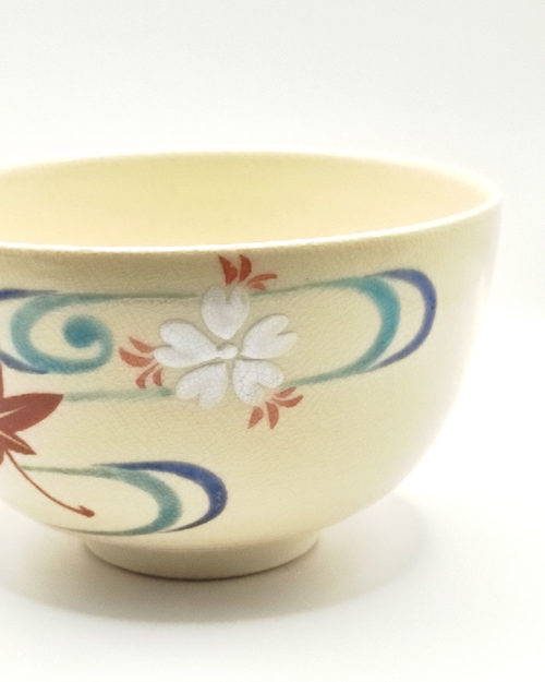 Vintage handmade Kyo-yaki Matcha bowl with maple leaf and sakura design on cream glaze, accented with blue curved lines.