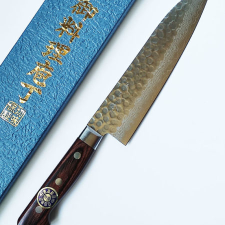 Japanese Santoku kitchen knife with hammered Damascus blade and mahogany handle with Tsuchime hammered finish. Handmade in Japan. Available at j-okini.com in Malta