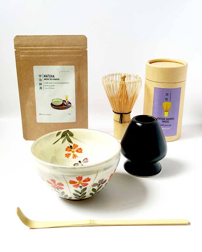 Japanese matcha starter set with a small Nadeshiko flower matcha bowl, bamboo whisk, bamboo scoop, whisk stand, and Uji Kyoto matcha tea.