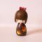 Kaede-chan Japanese wooden kokeshi doll by Kojo wearing a brown kimono decorated with yellow, orange and red maple leaves.