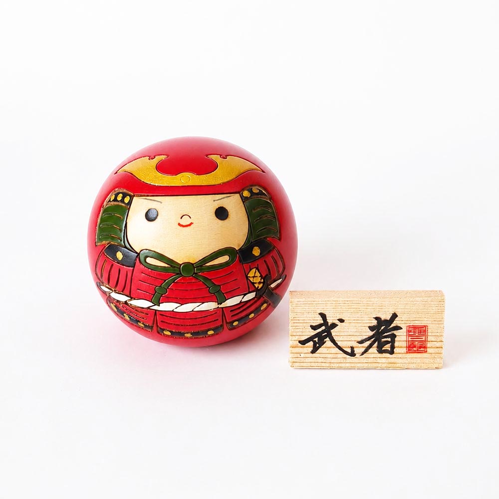 Musha round Japanese wooden kokeshi doll by Usaburo featuring a samurai in red armour with a wooden 武者 name plaque.